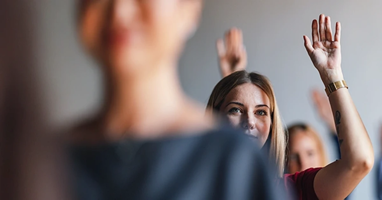 Zwei Kolleginnen heben gleichzeitig die Hände in erfolgreicher Büroatmosphäre. Erfolgreich Teams führen und entwickeln
