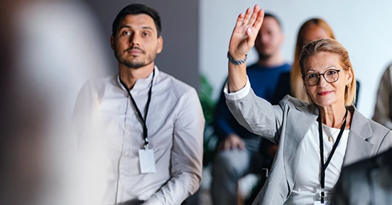 Selbstbewusste Geschäftsfrau zeigt Initiative durch Handzeichen während eines Meetings. Führen ohne Vorgesetztenfunktion