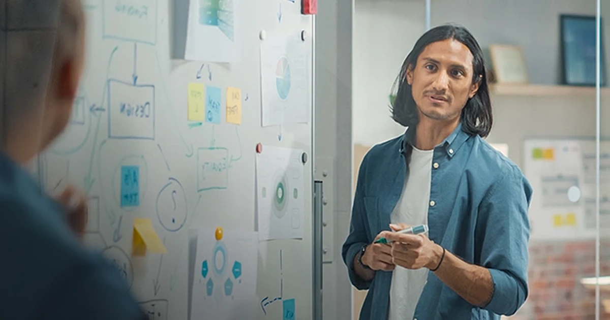 Mann vor Flipchart mit bunten Haftnotizen im Büro für Marketing