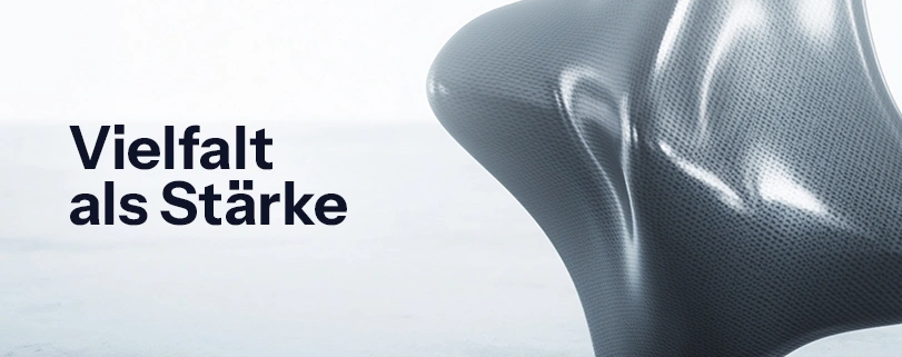 Abstrakte 3D-Skulptur auf hellem Hintergrund mit dem schwarzen Schriftzug „Vielfalt als Stärke". Diversität